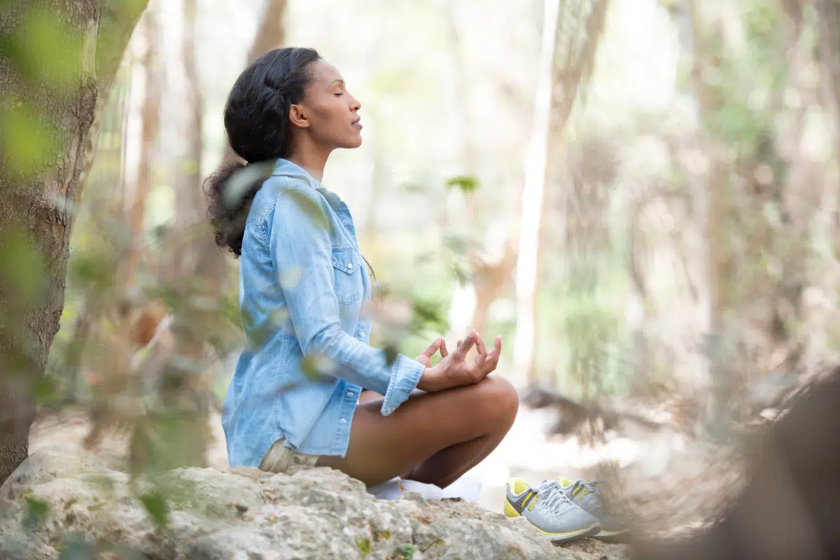 woman meditating in woods 