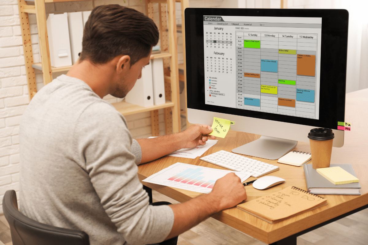 man using calendar to organize work 